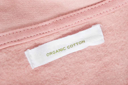 Clothing label says organic cotton on pink textile backgroundの写真素材