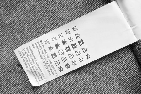 Care clothing label on black and white textile background