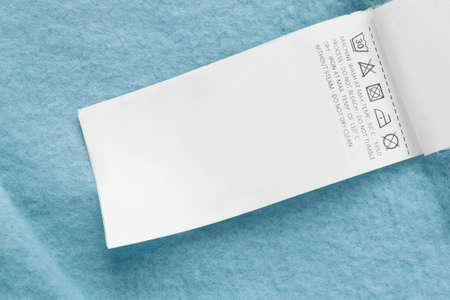 Care clothing label on blue textile background closeupの写真素材