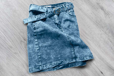 Crumpled denim mini skirt on white wooden backgroundの写真素材