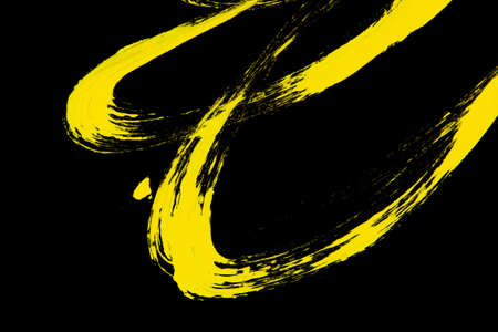Neon yellow acrylic paint stroke isolated over blackの写真素材