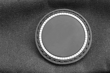 Blank rubber patch on black textile background closeup