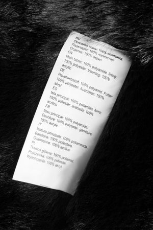 Fabric composition clothing label in different languages on black faux fur background