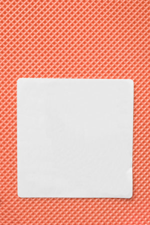 Blank white label on orange rubber background