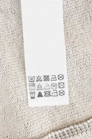 Care instructions clothing label on beige textile background