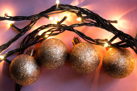 Golden christmas balls and flashing lights on purple background