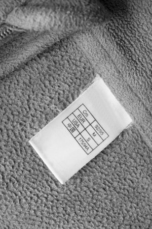 International size clothing label on gray textile backgroundの写真素材