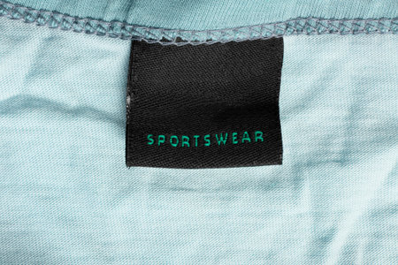 Clothing label says sportswear on blue textile background