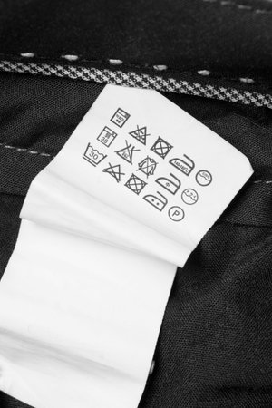 Care instructions clothing label on black textile background