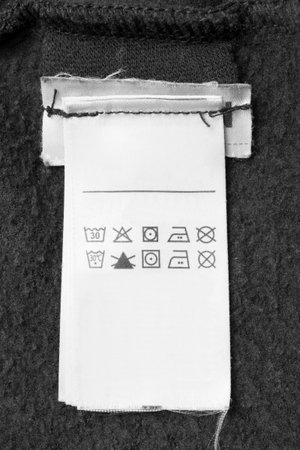 Care instructions clothing label on black textile backgroundの写真素材