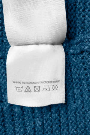 Washing instructions clothing label on blue knit backgroundの写真素材