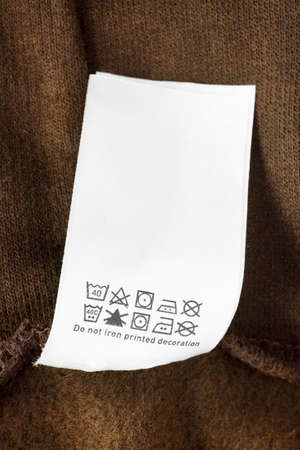 Care instructions clothing label on brown knit background closeupの写真素材