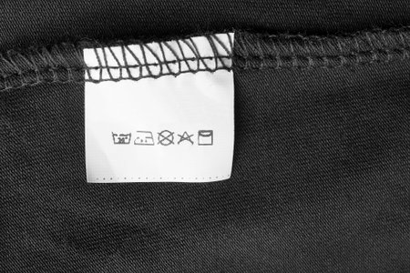 Care instructions clothing label on black textile backgroundの写真素材