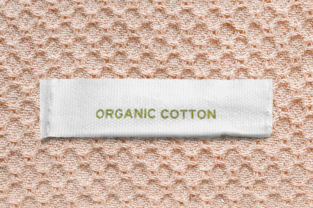 Clothing label says organic cotton on beige knit backgroundの写真素材