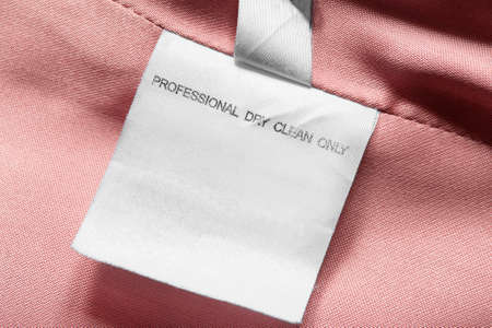 Care instructions clothing label on pink textile background closeupの写真素材