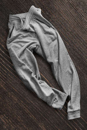 Gray sport pants on dark brown wood backgroundの写真素材