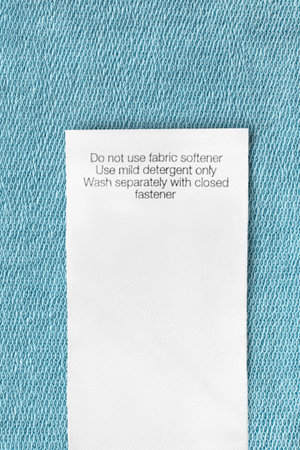 Care instructions clothing label on blue knit background