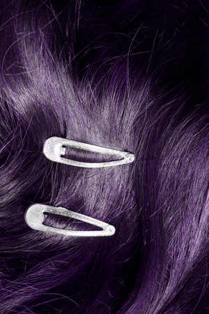 Two simple clip barrettes on dark purple hair closeupの写真素材