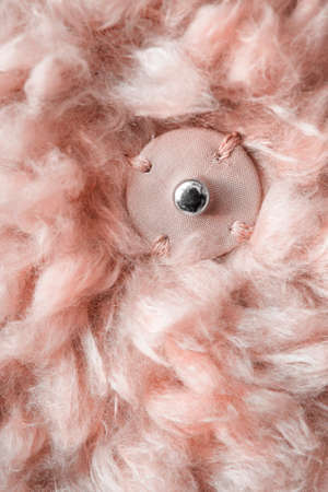 Sewn snap button on pink faux fur background closeupの写真素材
