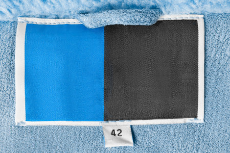 Size 42 black and blue clothing label on blue fabric background