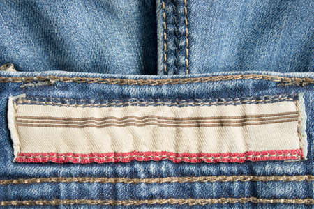 Empty clothing label stitched on blue denim backgroundの写真素材