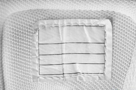 Empty paper patch stitched on white textile background
