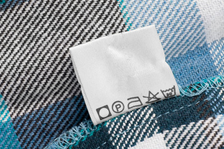 Care instructions clothing label on blue plaid fabric backgroundの写真素材