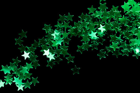 Abstract green glitter decorative stars on black backgroundの写真素材