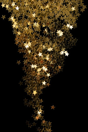 Decorative golden star shaped glitter on black backgroundの写真素材