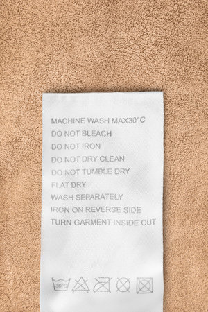 Care instructions clothing label on yellow fabric backgroundの写真素材