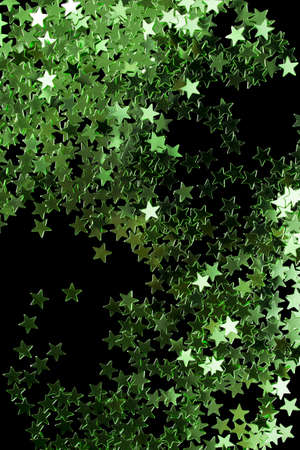 Green abstract star shaped glitter on black backgroundの写真素材