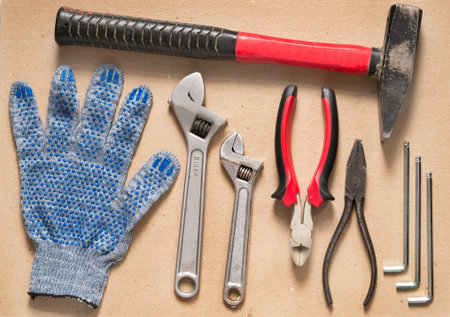 Hand tools set and protective glove on cardboard background