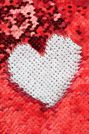 White heart shape on red reversible sequins fabricの写真素材