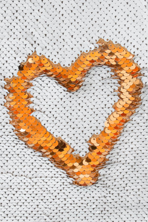 Orange sequins heart on white sequins fabric backgroundの写真素材