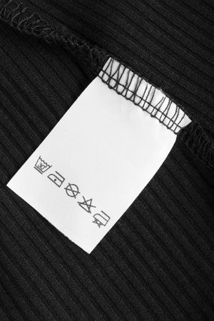 Care instructions clothing label on black fabric backgroundの写真素材