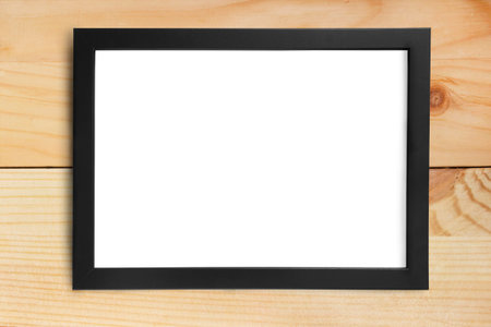 Empty simple black picture frame hanging on wooden plank wall