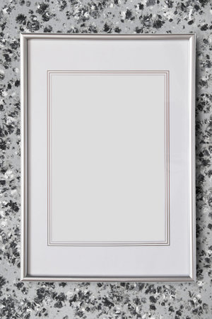 Empty silver fillet picture frame hanging on gray wall
