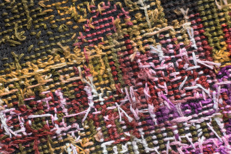 Abstract colorful embroidery back side on black canvas closeup as a background