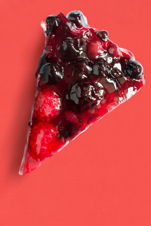 Piece of berry homemade cake on red background