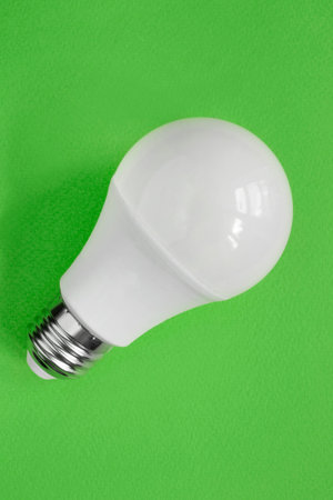 Energy saving led light bulb on green background