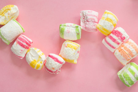 Colorful marshmallow candies on pink background