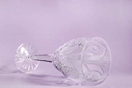 Empty vintage wineglass lying on purple backgroundの写真素材