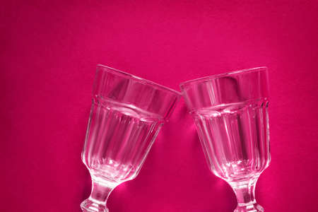 Clean vintage wineglasses cheers on maroon backgroundの写真素材