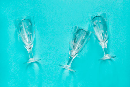 Three vintage clean wineglasses lying on blue backgroundの写真素材