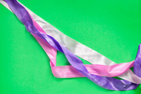 Abstract colorful satin ribbons on green background closeupの写真素材