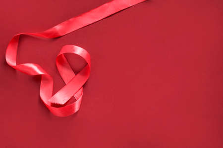 Red satin ribbon on red backgroundの写真素材