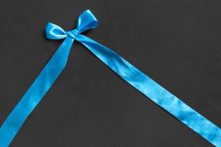 Blue tied bow satin ribbon on black background