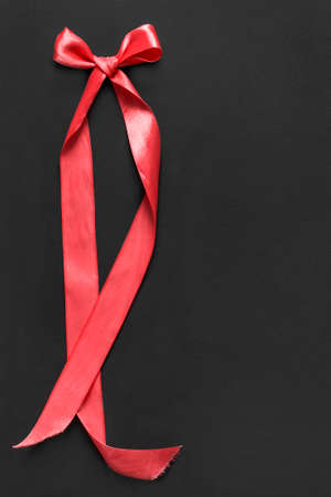 Red silk tied bow ribbon on black backgroundの写真素材