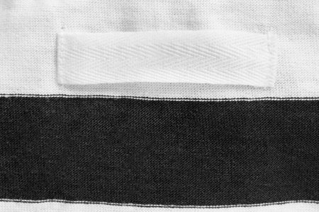 Blank clothing label on black and white fabric background