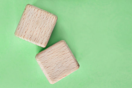 Two blank wooden cubes on green background